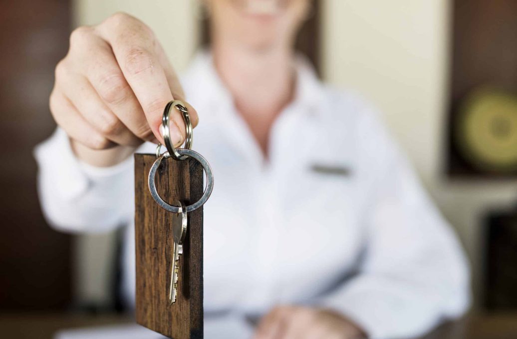 réceptionniste qui remet la clé de la chambre